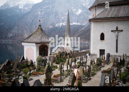 Graves overlooking Lake Hallstatt at the cemetery surrounding the Roman Catholic Parish Church of Hallstatt, Salzkammergut region, Austria Stock Photo