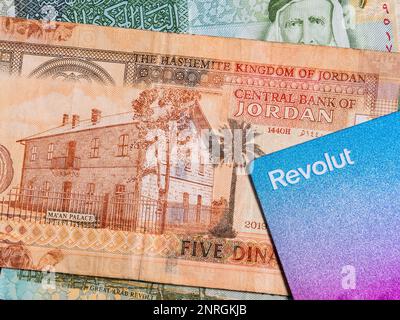 Macro detail picture with 5 Jordanian dinar banknote and a Revolut credit or debit card. JOD is the official currency in The Hashemite Kingdom of Jord Stock Photo