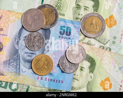 Macro detail with a 50 Thai Baht banknote and different coins. the baht is the official currency of Thailand Stock Photo