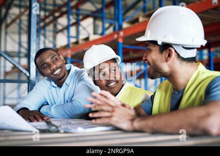 Designing the future, today. a group of builders having a meeting at a construction site. Stock Photo