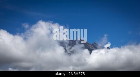 Peak of Mount Kinabalu in background as clouds cover the rest of the mountain. Mount Kinabalu is highest mountain in Borneo and Malaysia. Stock Photo