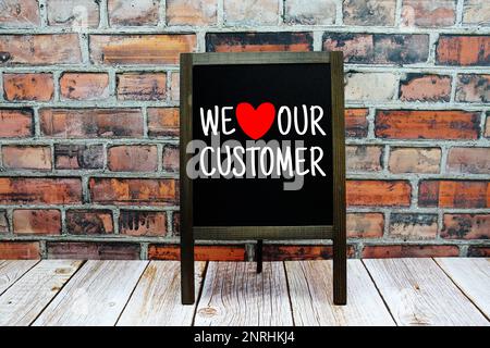 We Love Our Customer typography text on easel blackboard Stock Photo