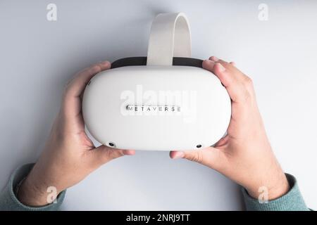 Hands with virtual reality glasses and the word metaverse. Concept of interaction and innovation Stock Photo