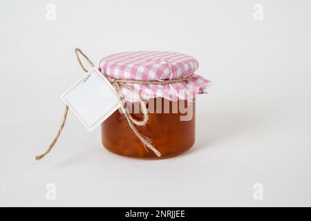 Jar of homemade apricot jam with empty label isolated on white background Stock Photo