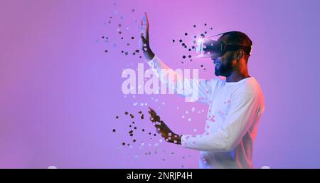 Black man in VR headset touching something invisible, copy space Stock Photo