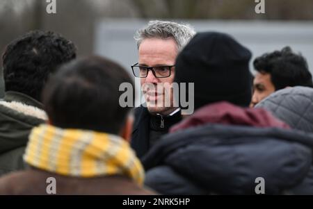 Bensheim, Germany. 10th Feb, 2023. Christian Engelhardt (CDU, M), District Administrator of Bergstrasse County, talks to war refugees from Syria on the grounds of the refugee shelter. Cities and communities can hardly accommodate the number of refugees. The Bergstrasse district is not alone in calling for more support from the federal and state governments. Credit: Arne Dedert/dpa/Alamy Live News Stock Photo