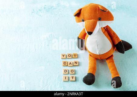 You can do it, motivational banner with a toy fox on a blue background with copy space Stock Photo