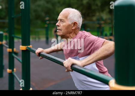 Senior european man doing push-ups outdoors Stock Photo