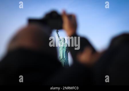 Tourists taking pictures of the Statue of Liberty on a boat. Stock Photo