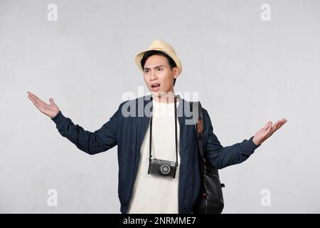 Young traveler man doubting and shrugging shoulders in questioning gesture. Stock Photo