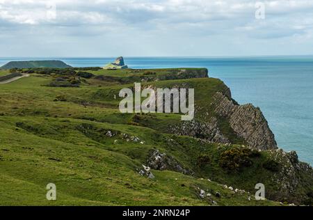 View from Rhossili Car Park down along the Rhossili clifftops as far as the top of The Worms Head on the Gower Peninsula South Wales Stock Photo
