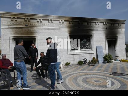 Hawara, Gaza. 27th Feb, 2023. Palestinian stand outside a house burned by Israeli settlers in a revenge attack after two Israeli brothers were killed yesterday by a Palestinian gunman in Hawara, in the West Bank, on Monday, February 27, 2023. Photo by Debbie Hill/ Credit: UPI/Alamy Live News Stock Photo