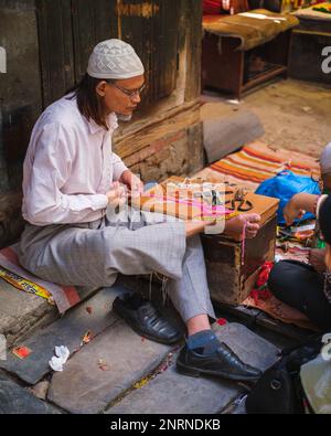 Kathmandu, Nepal, 04 23 2022: Webster knitting cloth with his feet Stock Photo