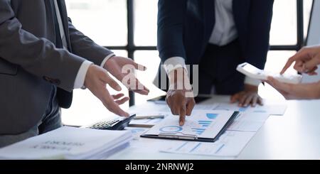 Businessman and team analyzing financial statement Finance task. with tablet and .calculator. Wealth management concept Stock Photo