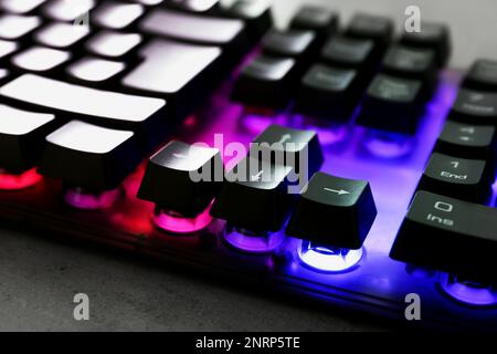 Modern keyboard with RGB lighting on grey table, closeup Stock Photo