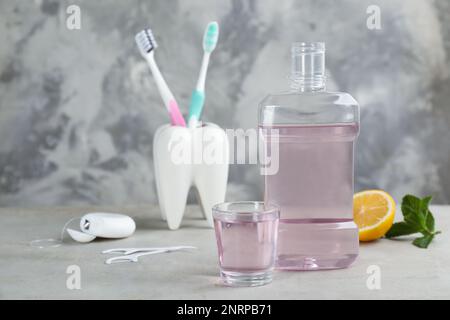 Mouthwash and other oral hygiene products on grey table, space for text Stock Photo