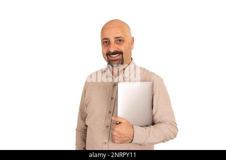 Smiling man hugging notebook. Isolated white background win concept idea. Holding modern laptop. Positive caucasian male office worker posing. Stock Photo