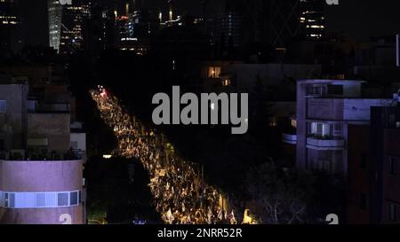 TEL AVIV, ISRAEL - FEBRUARY 25: Anti-government protesters hold Israeli flags as they march during a demonstration against Israel's Prime Minister Benjamin Netanyahu's new right-wing coalition and its proposed judicial changes that aims to weaken the country's Supreme Court on February 25, 2023 in Tel Aviv, Israel. Tens of thousands rally for eighth consecutive week across Israel against the wide ranging and controversial reform in Israel's legal system. Stock Photo