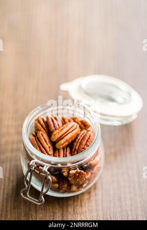 Peeled pecan nuts in jar on the kitchen table. Stock Photo