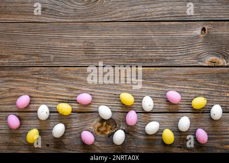 Multicolored Easter eggs on a wooden background, flat lay. Stock Photo