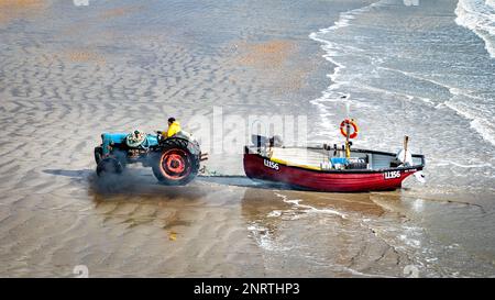 BOGNOR REGIS, UK, 27th February 2023, UK Weather: An inshore fisherman tows his wooden boat in from the sea after sailing out on a crisp winter's day with the sun shining but a chilly wind blowing. Credit: Andy Soloman/Alamay Live News Stock Photo