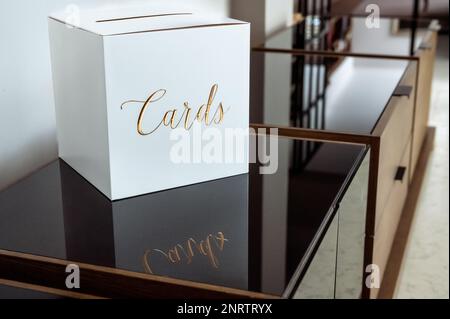 a white box with gold lettering for greeting envelopes standing on a reflective surface Stock Photo
