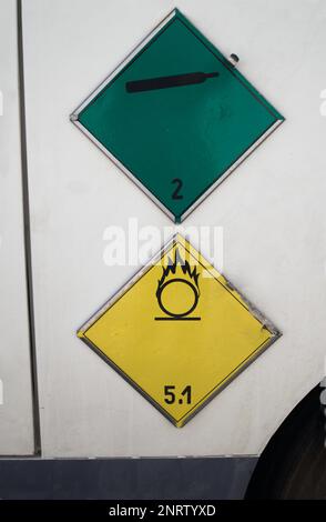 Two stickers indicating the type of product transported by a truck.The green sticker indicates the transport of non-flammable and non-toxic gases.The Stock Photo