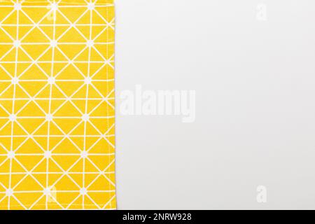 top view with yellow empty kitchen napkin isolated on table background. Folded cloth for mockup with copy space, Flat lay. Minimal style. Stock Photo