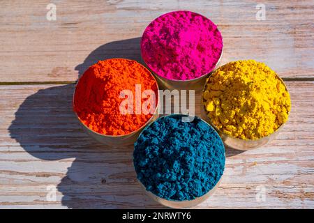 Colorful powder organic Gulal colors in bowls for Indian Holi festival. Wooden background. High quality photo Stock Photo