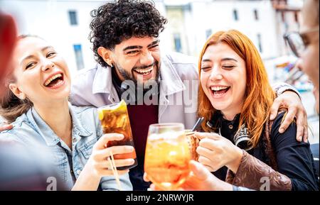 Trendy people having fun drinking at open air bar dehor - Beverage life style concept with  guys and girls enjoying time together sharing fancy cockta Stock Photo