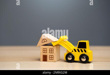 The bulldozer demolishes the house. Encroachment on private property. Illegal buildings and construction. Violation of building codes. Housing renovat Stock Photo