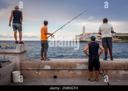 Fishermen, in Malecón,on the background the Castillo de los Tres Reyes del Morro, La Habana, Cuba Stock Photo