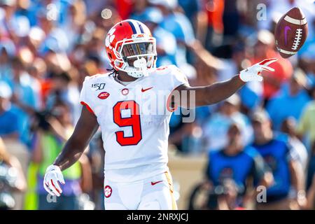 Clemson's Trevor Lawrence (16) hands the ball off to Travis Etienne (9)  during the first half of an NCAA college football game against North  Carolina State in Raleigh, N.C., Saturday, Nov. 9