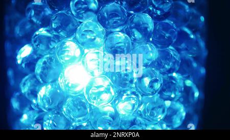 Water colored, blue gel balls. Super macro bubbles slow motion. Background with hydrogel balls with glitter. The concept of cosmetology. Luminous, shi Stock Photo