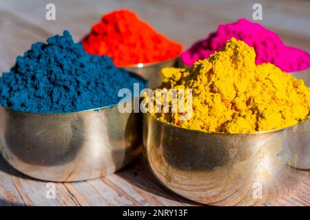 Colorful powder organic Gulal colors in bowls for Indian Holi festival. Wooden background. High quality photo Stock Photo