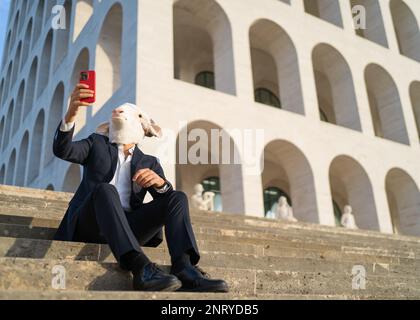 business with sheep head sitting taking a selfie on lunch break, copy space Stock Photo