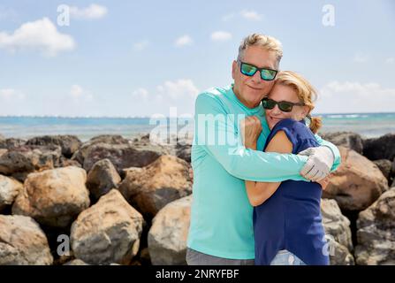 Senior Couple with hugging each with ocean in background Stock Photo