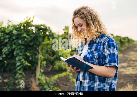 Agriculture woman analysing data, chart and graph on notepad. Smart farming and innovation technology. Artificial intelligence technology. Monitoring Stock Photo