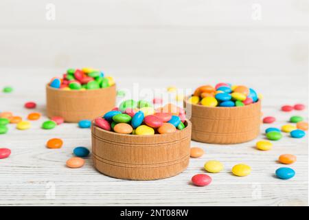 Multicolored candies in a bowl on a colored background. birthday and holiday concept. Top view with copy space. Stock Photo