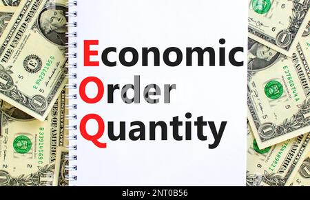 EOQ economic order quantity symbol. Concept words EOQ economic order quantity on white note on a beautiful background from dollar bills. Business and Stock Photo