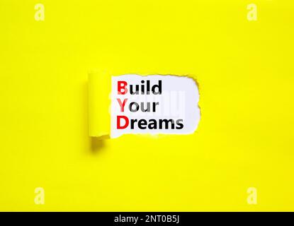 BYD build your dreams symbol. Concept words BYD build your dreams on white paper on a beautiful yellow background. Business and BYD build your dreams Stock Photo