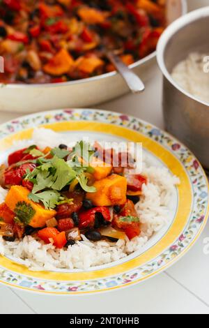 Feijoada - Brazilian Black Bean Stew with sweet potatoes, tomatoes and peppers on rice. Stock Photo