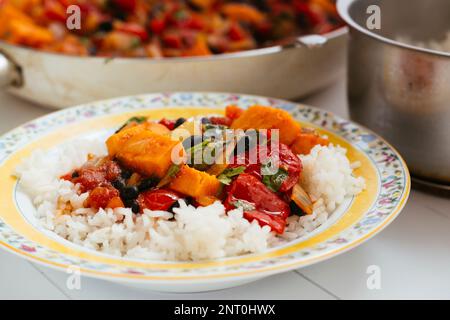 Feijoada - Brazilian Black Bean Stew with sweet potatoes, tomatoes and peppers on rice. Stock Photo