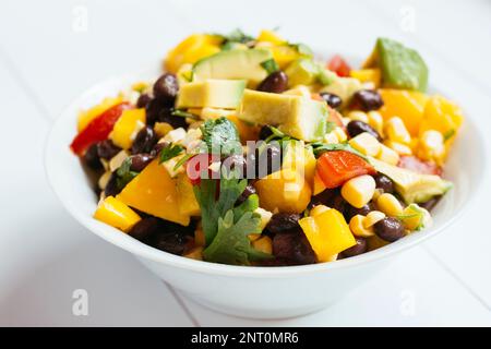 Southwestern Salad with black beans, corn, tomatoes, yellow bell pepper, mango, avocado and coriander Stock Photo