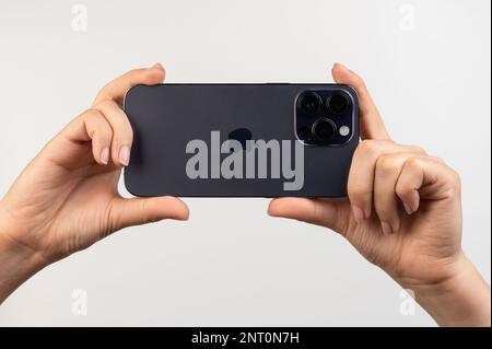 New york, USA - February 24, 2023: Taking photo with new iphone 14 pro max in hands isolated on white studio background Stock Photo