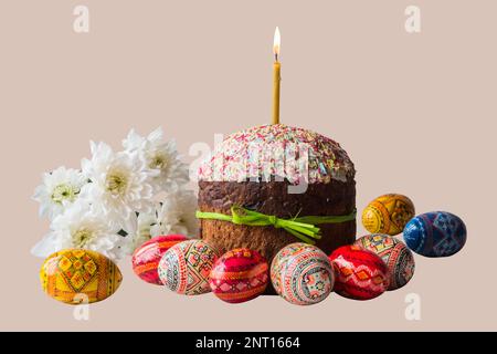 Easter cake kulich lighted candle and painted eggs with spring flowers on isolated background Stock Photo