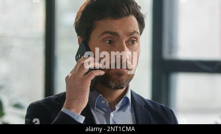 Close-up frustrated businessman aggressive loud talk on phone in office angry nervous man leader CEO discuss business problems on cellphone feel Stock Photo