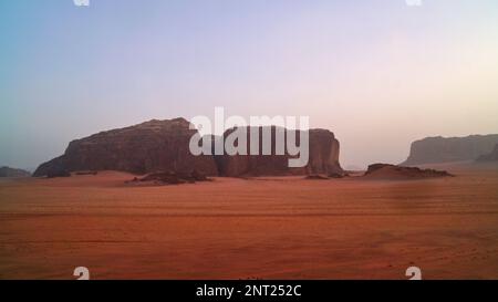 Sunset time rocks in Wadi Rum desert (The Valley of the Moon). Jordan, Middle East.  Red sands, sky with haze. Designation as a UNESCO World Heritage Stock Photo