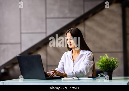 Beauitul young woman working using computer laptop concentrated and smiling Stock Photo