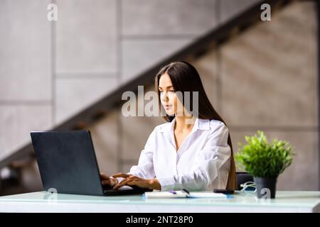 Beauitul young woman working using computer laptop concentrated and smiling Stock Photo